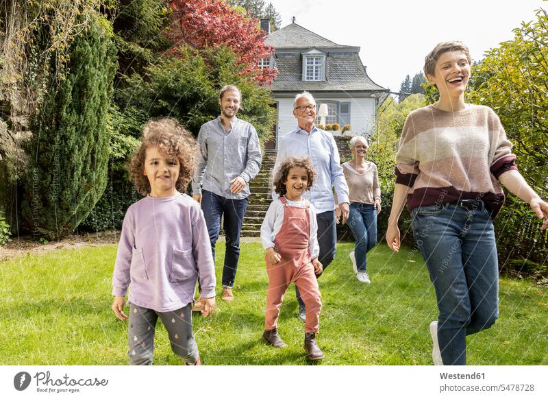 Happy extended family walking in garden of their home generation human human being human beings humans person persons families Multi Generations Families