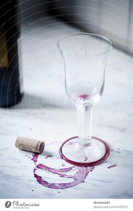 Empty red wine glass, bottle, stains and wine cork on white marble nobody still life still lifes still-life still-lifes transparent western script three objects