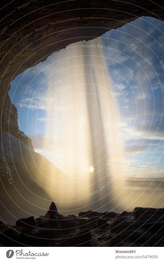 Seljalandsfoss Waterfall against the sun, Iceland in the evening Late Evening rocks cavern caverns caves skies clouds sunny Sunny Day Sunlit Athmospheric Mood