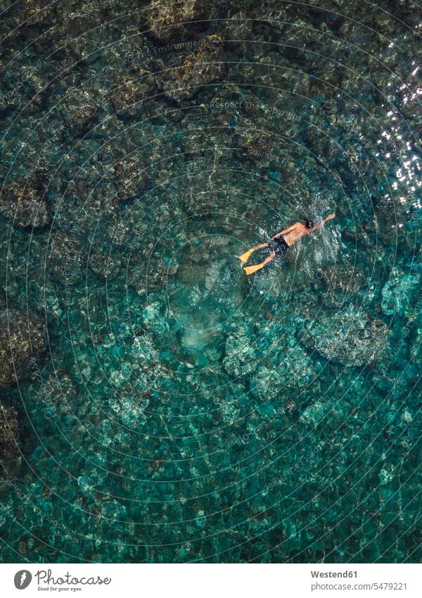 Indonesia, Bali, Man swimming in ocean at Amed beach discovering Incidental people People In The Background background person People In Background