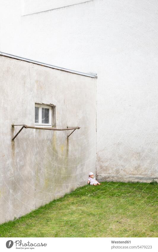 Germany, glum backyard with doll siiting on grass in a corner single object 1 one bar bars childhood courts courtyard courtyards dull attachment fittings