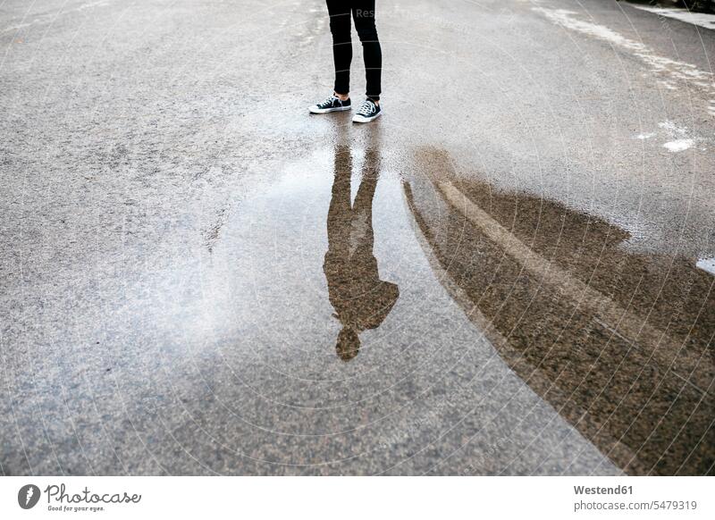 Reflection of a man in a puddle on the floor floors men males water reflection water reflections puddles pool standing mirrored Reflected mirroring waiting
