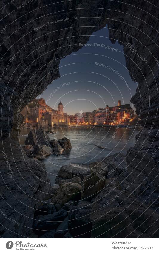 Italy, Cinque Terre, Vernazza seen from rocky coast at dusk outdoors location shots outdoor shot outdoor shots evening twilight in the evening Late Evening