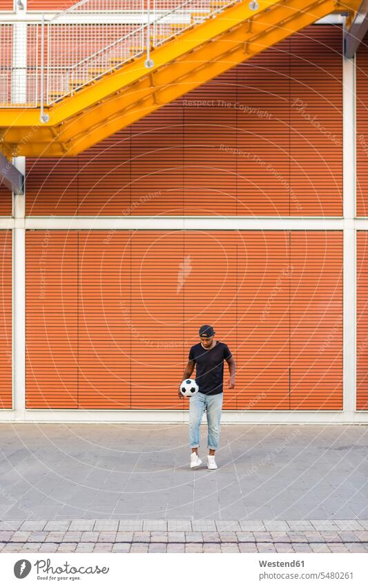 Young man playing with soccer ball soccer balls footballs men males Adults grown-ups grownups adult people persons human being humans human beings