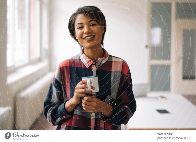 Portrait of smiling young woman holding cup females women smile Coffee businesswoman businesswomen business woman business women Adults grown-ups grownups adult