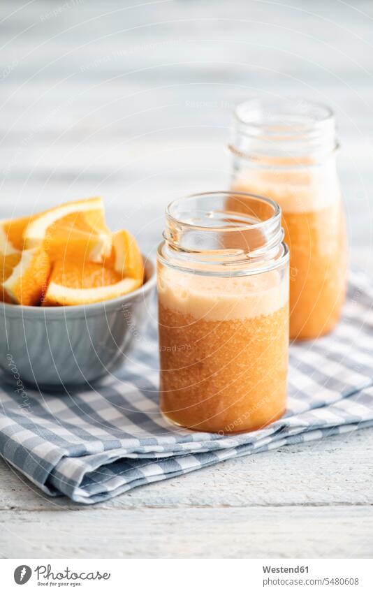 Orange, carrot, pineapple, ginger smoothie in jars Glass Glasses Fruit Smoothie kitchen towel Smoothies orange slice orange slices lifestyle life styles