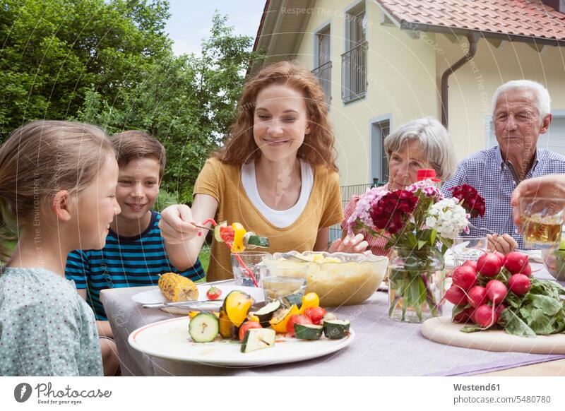 Extended family dining in garden happiness happy eating generations families gardens domestic garden people persons human being humans human beings mother mommy