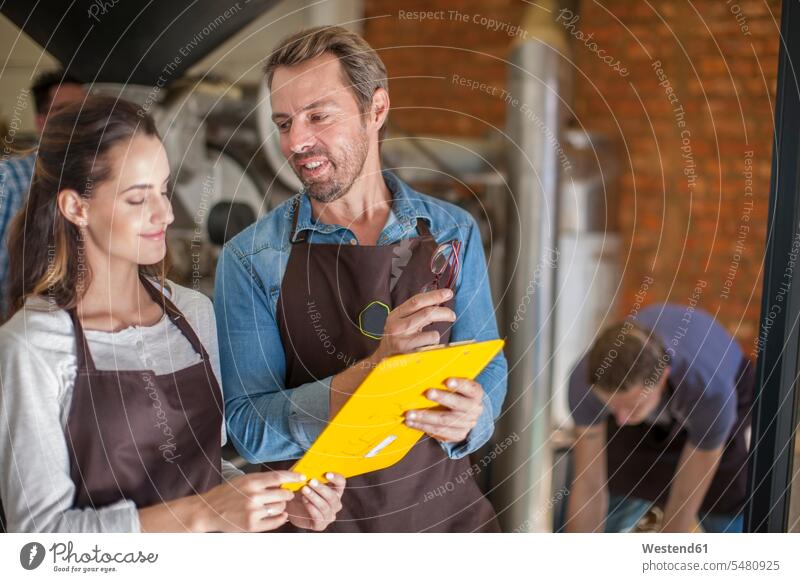 People roasting coffee looking at clipboard scrutiny scrutinizing factory colleagues working At Work industry industrial occupation profession