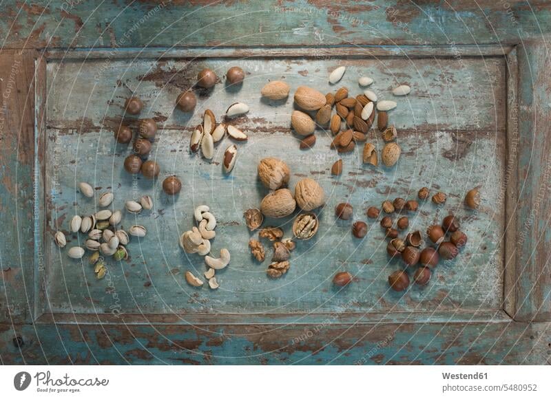 Different sorts of nuts on wood Variety diversity Diverse varied diversification variation wooden rustic macadamia nut macadamia nuts peel shell shells peels