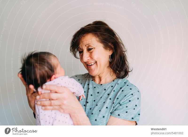 Happy grandmother holding her granddaughter grandmas grandmothers granny grannies grandchild grandchildren smiling smile happiness happy babies infants baby