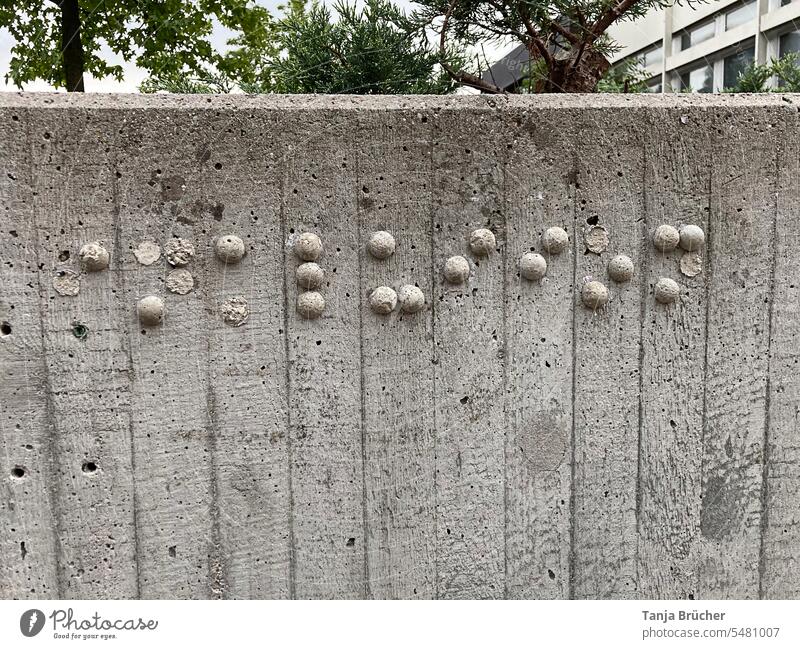 Crumbling braille from concrete balls on a gray concrete wall Braille script Blind For blind visually impaired visual impairment Concrete Read with fingers