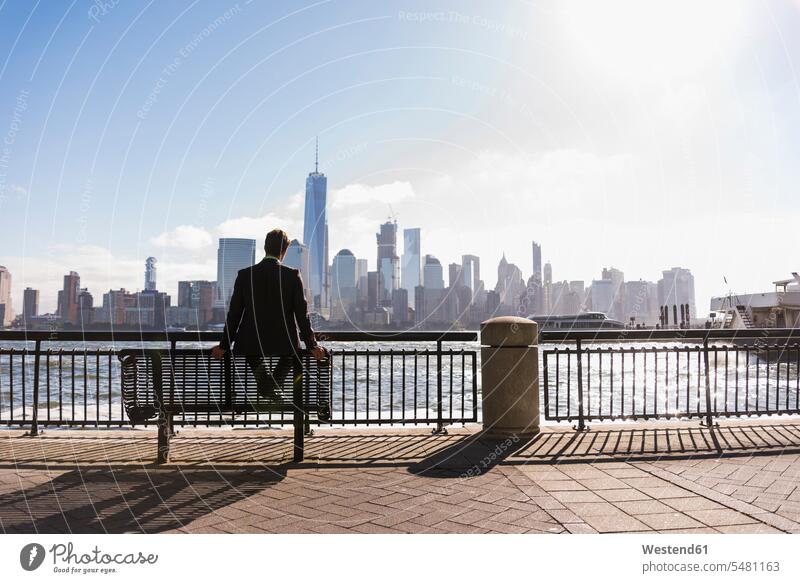 USA, man sitting on Photocase Royalty waterfront Photo view with Jersey from Free at a Manhattan Stock to bench New 