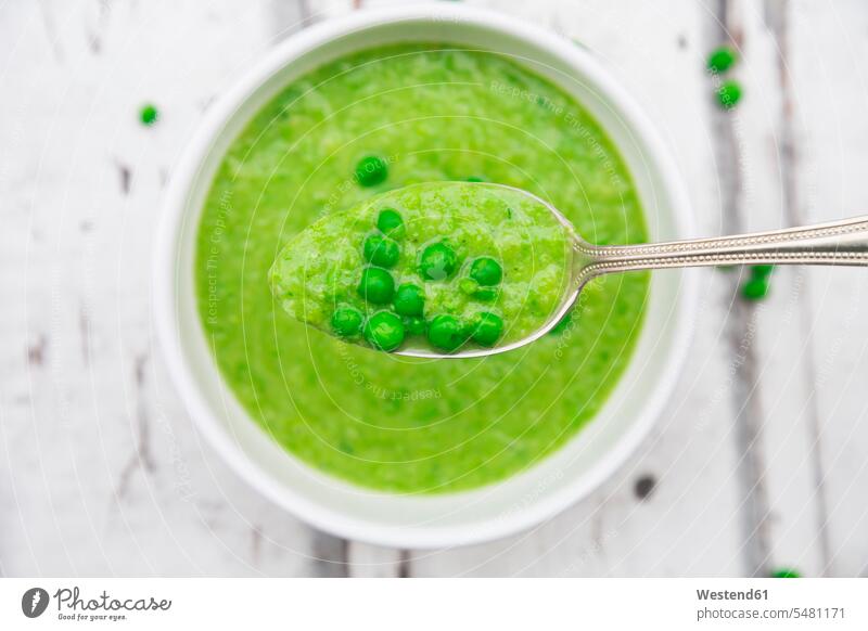 Spoon of pea soup and peas bright green chartreuse light green prepared creme of vegetable soup ready to eat ready-to-eat Vegetable Soup Vegetable Soups mashed