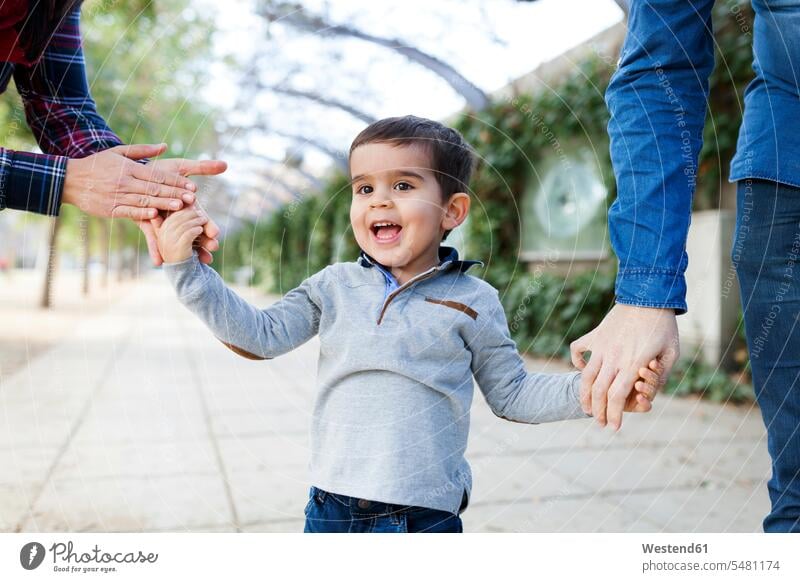 Portrait of happy toddler walking hand in hand with his parents caucasian caucasian ethnicity caucasian appearance european two parents portrait portraits