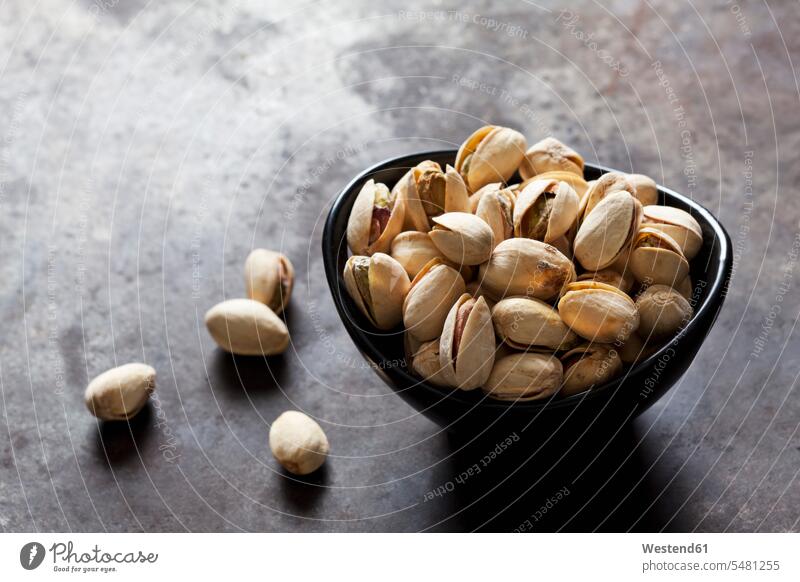 Bowl of roasted and salted pistachios on slate Pistachio Pistachios pistachio nut nutshell nutshells focus on foreground Focus In The Foreground