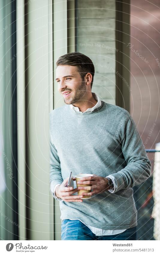 Smiling young man looking out of window caucasian caucasian ethnicity caucasian appearance european Germany indoors indoor shot Interiors indoor shots