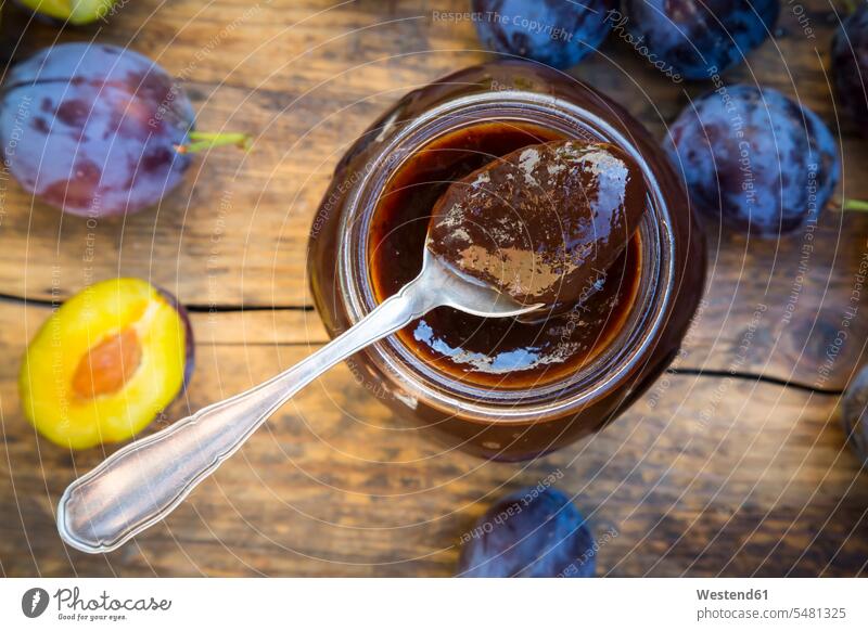 Tea spoon of plum jam on preserving jar and plums on wood whole uncooked jam jar jam jars Plum Jam Plum Marmalade Prune Jam raw homemade home made home-made