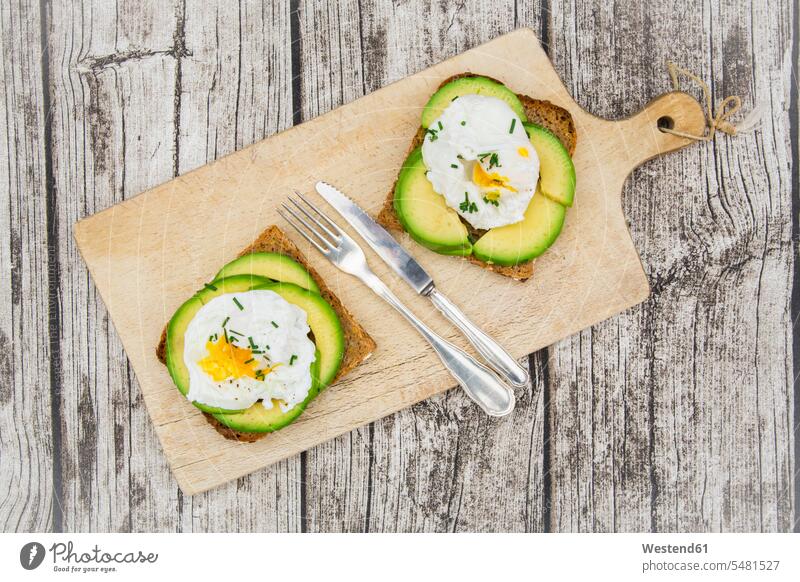 Wholemeal bread slices with sliced avocado and poached eggs on wooden board food and drink Nutrition Alimentation Food and Drinks Snack Snacks Snack Food