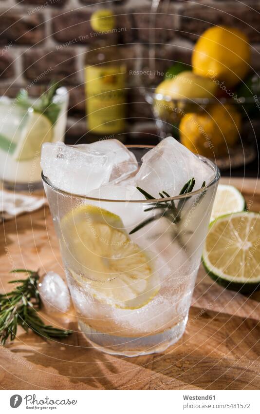 Glass of Gin Tonic with lemon, rosmary and ice Drinking Glasses enjoyment indulgence lifestyle life styles wooden rosemary aroma flavour aromatic lemon slice