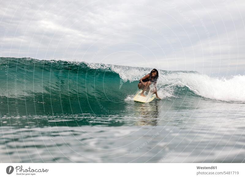 Indonesia, Java, woman surfing Sea ocean surf ride surf riding Surfboarding females women wave waves water water sports Water Sport aquatics Adults grown-ups