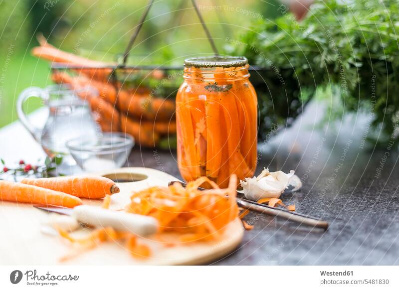 Fermented carrots in preserving jar dill Anetum Graveolens preparation prepare preparing spice flavouring flavoring spices Chopping Board Cutting Boards