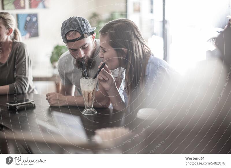 Man and woman sharing milkshake in coffee shop caucasian caucasian ethnicity caucasian appearance european drinking Milkshake Milkshakes Incidental people