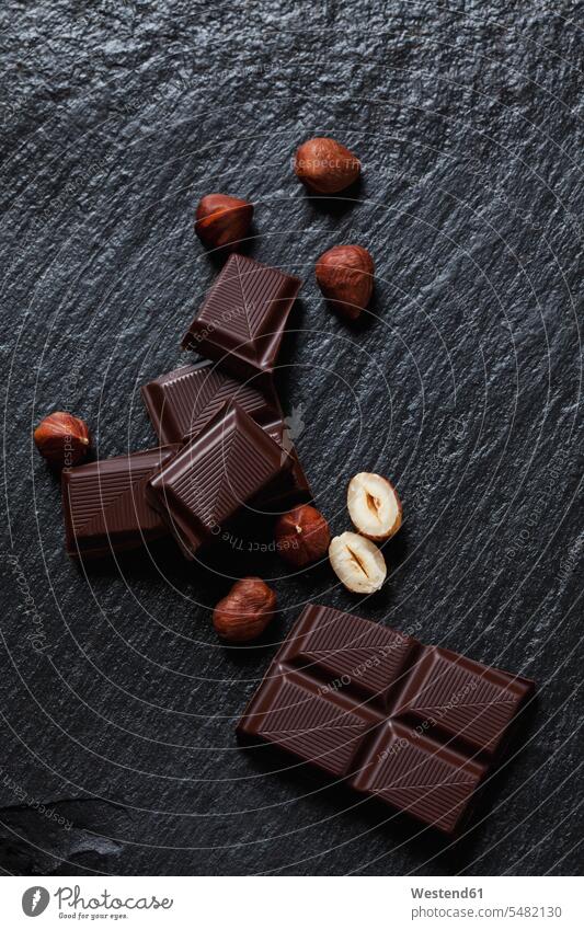 Bittersweet chocolate and hazelnuts on slate black background black backgrounds arrangement grouping chocolate bar chocolate bars bittersweet chocolate