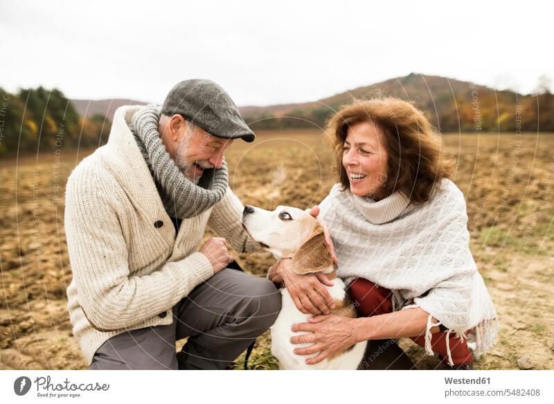 Happy senior couple with dog in nature dogs Canine elder couples senior couples pets animal creatures animals adult couple adult couples twosomes partnership