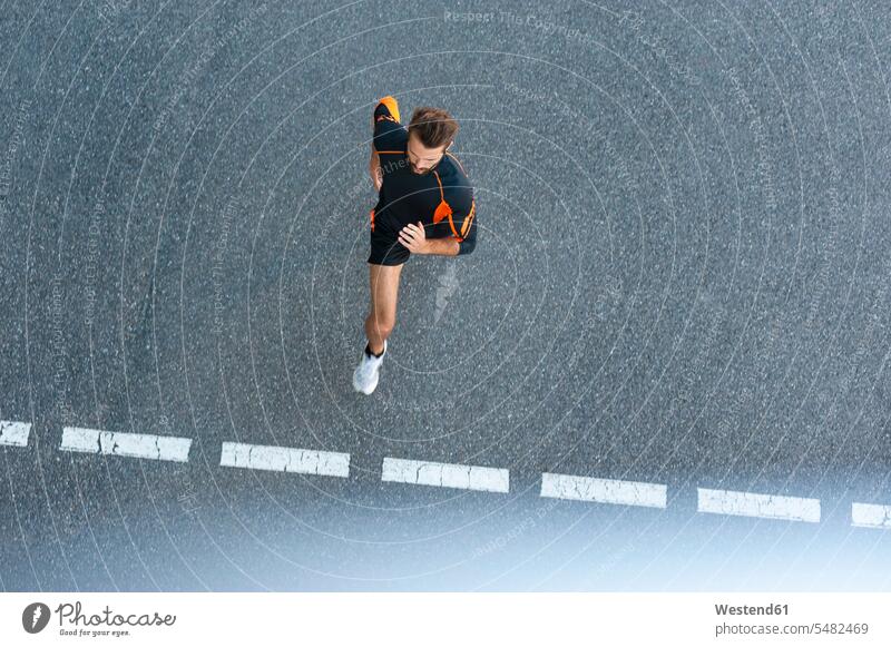 Man running on street with markings man men males Jogging Adults grown-ups grownups adult people persons human being humans human beings fitness sport sports