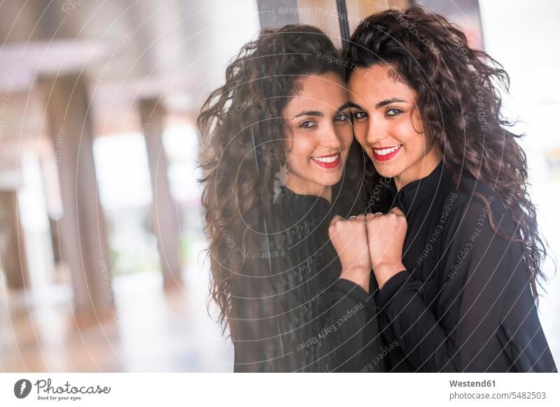 Portrait of smiling teenage girl reflecting at glass pane caucasian caucasian ethnicity caucasian appearance european looking at camera looking to camera