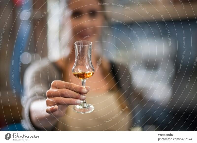 Woman holding liquor glass - a Royalty Free Stock Photo from Photocase