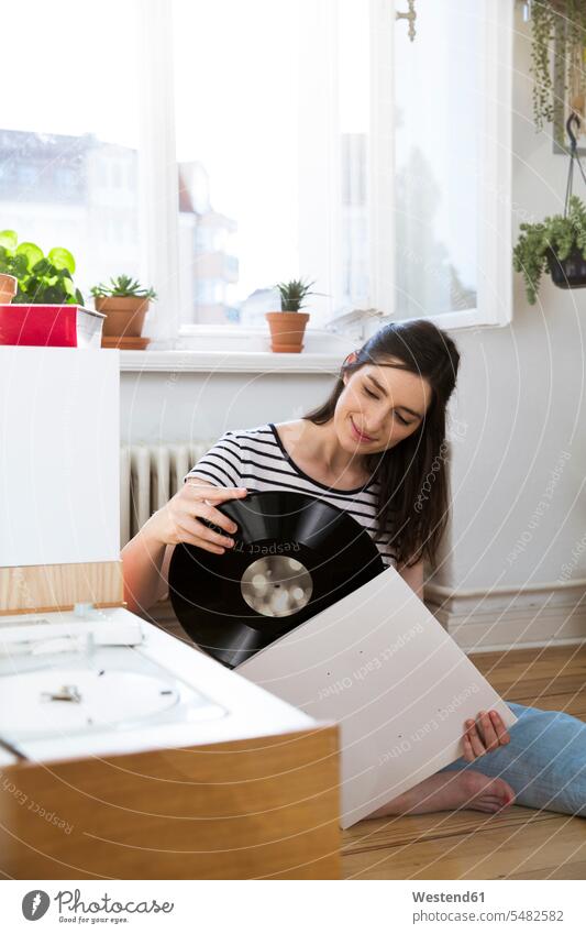 Smiling wman at home with record vinyl record records woman females women smiling smile analogue Media Adults grown-ups grownups adult people persons
