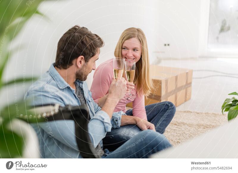 Couple toasting champagne glasses at their new home drinking togetherness Change Changes Changing new house Germany face to face Facing Each Other