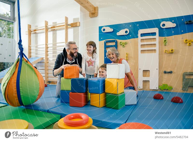 Happy children and teachers in gym room in kindergarten Fun having fun funny sports hall sports halls kid kids educator nursery school building buildings people