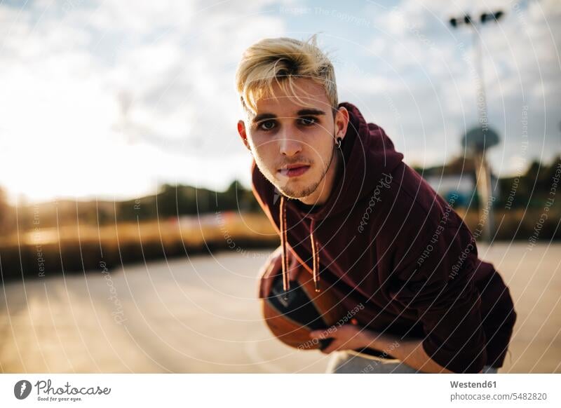 Portrait of young man playing basketball on an outdoor court determination decided determined decidedness balls casual leisure wear casual clothing casual wear
