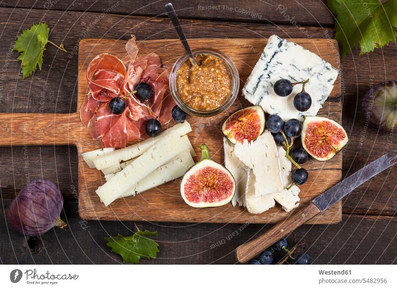 Cheese platter with fruits and fig mustard food and drink Nutrition Alimentation Food and Drinks dark wood Ham Fruit Fruits knife knives blue grape red grape