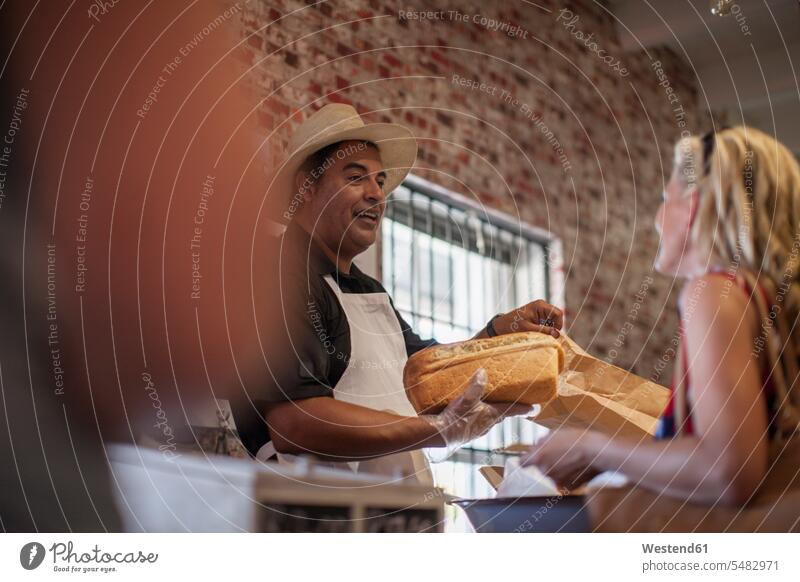 Shopkeeper in shop helping client, white bread man men males friendly nice customer clientele clients customers shopkeeper shopkeepers White Bread White Breads