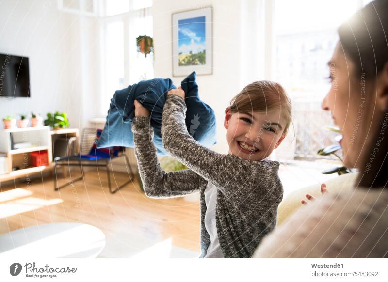 Happy mother with daughter at home having a pillow fight Fun having fun funny laughing Laughter mommy mothers ma mummy mama daughters positive Emotion Feeling