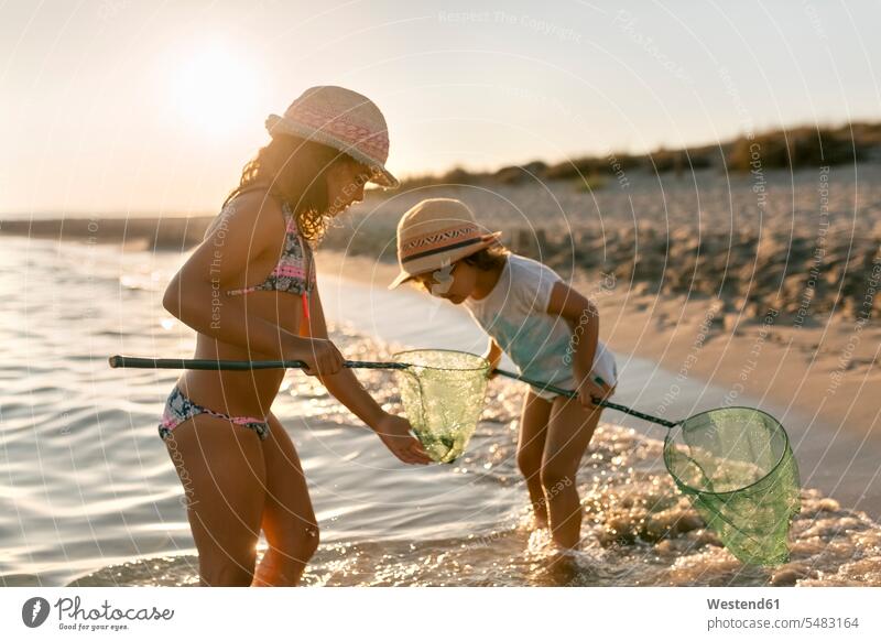 Spain, Menorca, portrait of a girl with a dip net on the beach - a