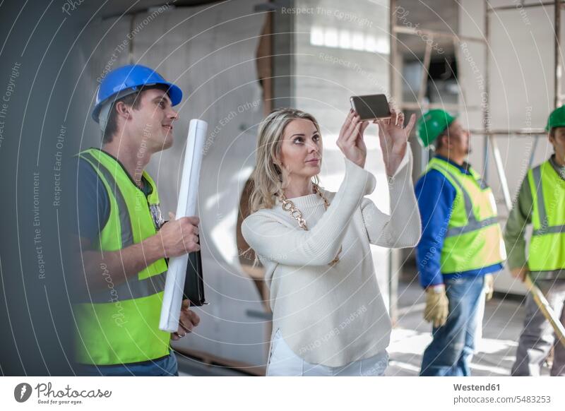 Construction workers and woman on construction site mobile phone mobiles mobile phones Cellphone cell phone cell phones Building Site sites Building Sites