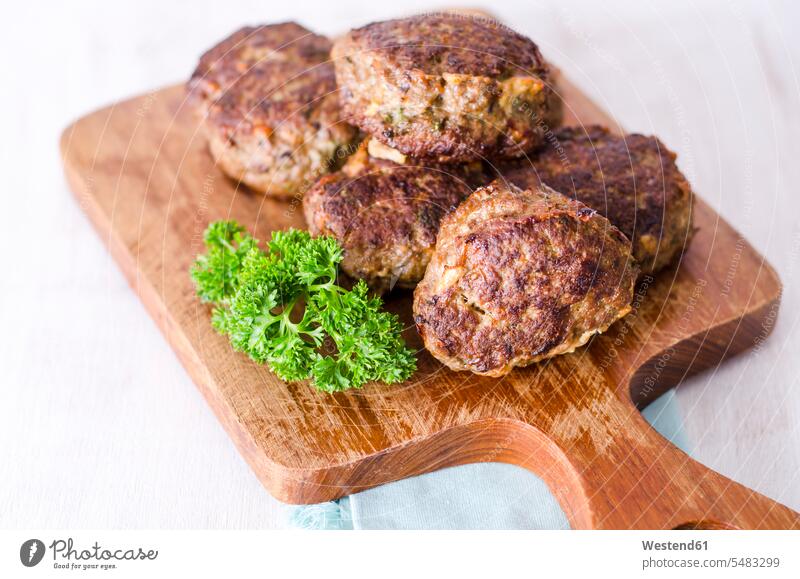Homemade patties of ground beef with parsley on chopping board Chopping Board Cutting Boards Chopping Boards mincemeat minced meat fried roast homemade