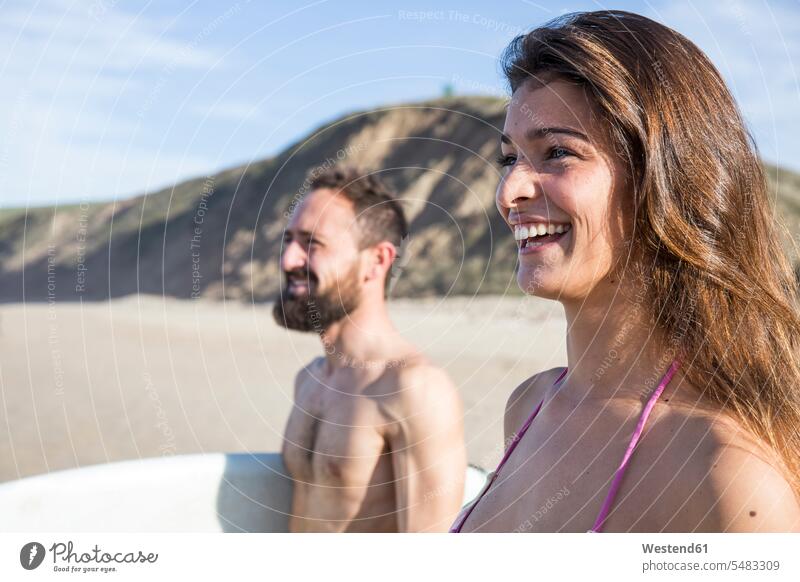 Happy couple on the beach surfer surfers beaches twosomes partnership couples surfing surf ride surf riding Surfboarding water sports Water Sport aquatics