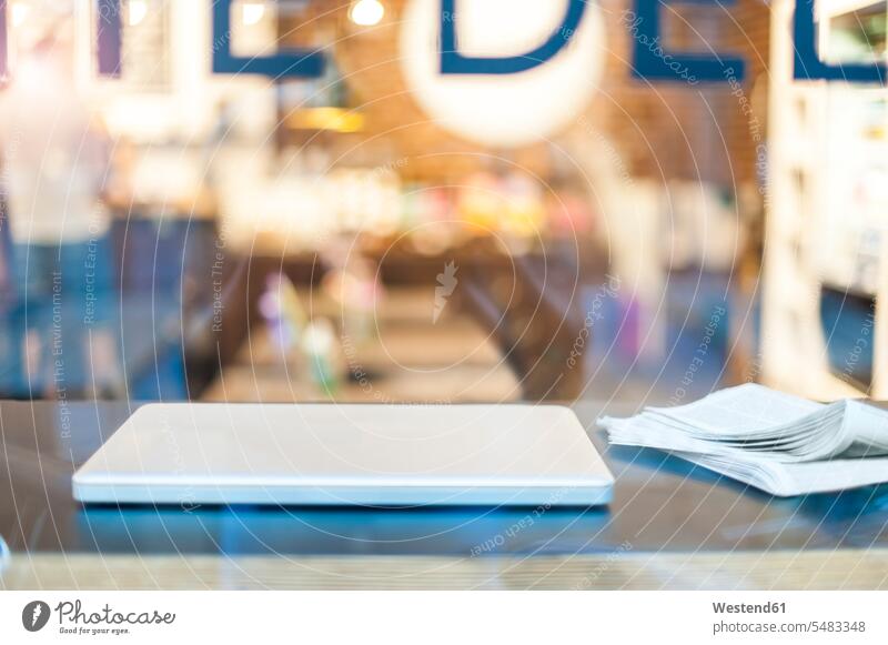 Laptop and newspaper on table in a cafe Mobility mobile mobile working Germany close-up close up closeups close ups close-ups laptop Laptop Computers laptops