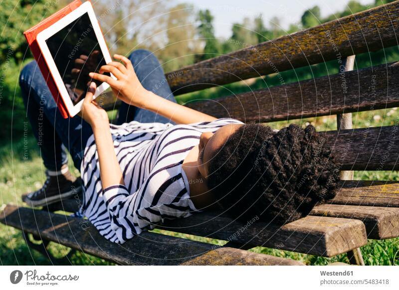 Young woman lying on park bench using digital tablet digitizer Tablet Computer Tablet PC Tablet Computers iPad Digital Tablet digital tablets females women