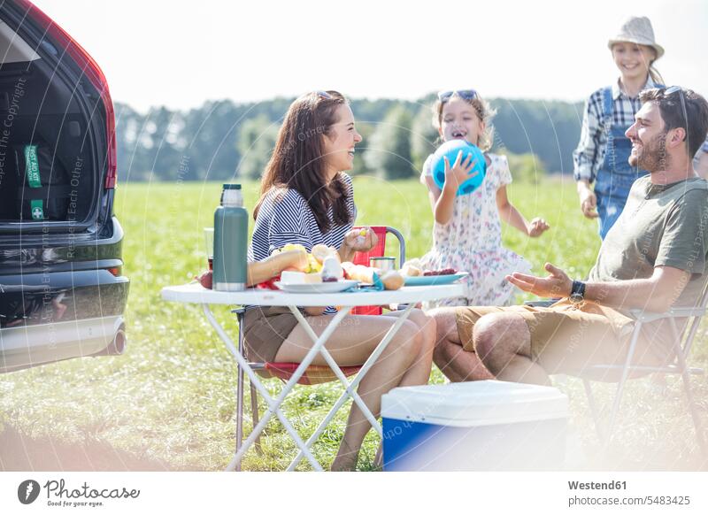 Happy family on a road trip taking a break at the road side resting meadow meadows Taking a Break families car automobile Auto cars motorcars Automobiles