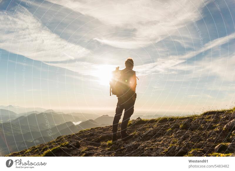 Austria, Salzkammergut, Hiker standing on summit, looking at view mountain range mountains mountain ranges active hiking hike mountaintops summits mountain top