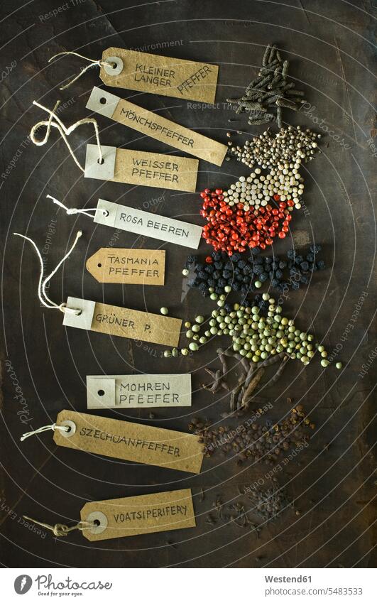 Various sorts of pepper and labelled tags Xylopia aethiopica dark background selection Assortment Brown Background brown western script pink peppercorn name