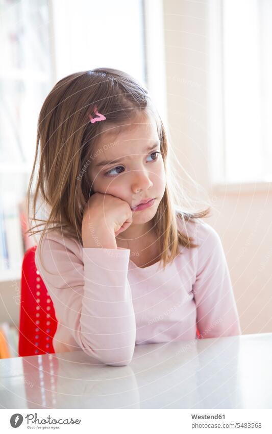 Portrait of sad little girl at table Table Tables Disappointment disappointed leaning rested on portrait portraits serious earnest Seriousness austere females