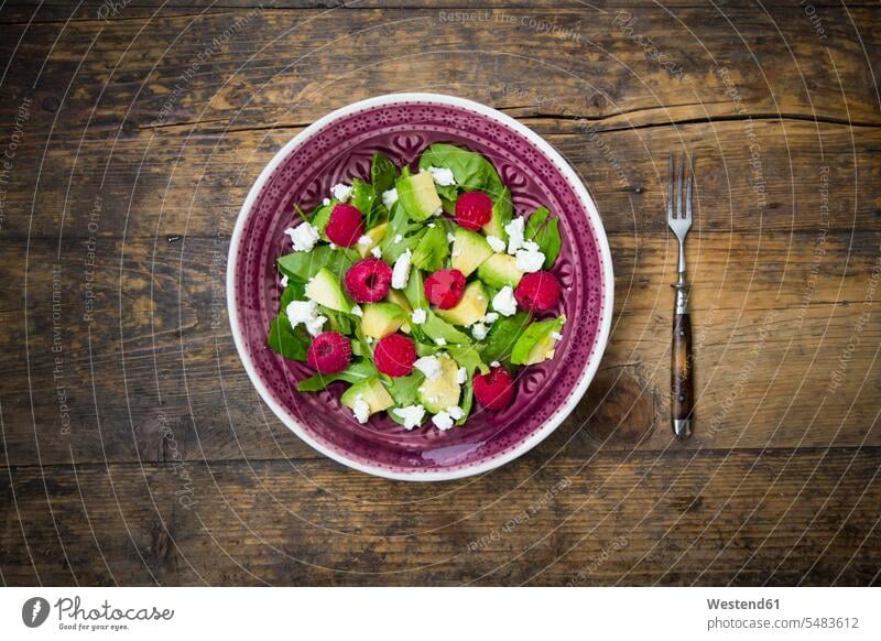 Bowl of avocado raspberry salad with feta on dark wood Fork Forks wooden rustic salad bowl salad bowls snack fruit sliced Raw Food Feta cheese healthy eating