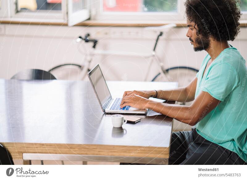 Young man sitting at desk in office and working on computer. Stock